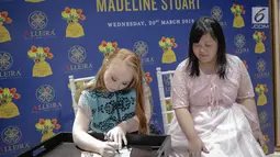 Model Madeline Stuart menandatangani foto dirinya untuk penggemar selama meet and greet di Alleira Batik Plaza Indonesia, Jakarta, Rabu (20/3). Madeline Stuart adalah model penderita down syndrome pertama asal Australia. (Liputan6.com/Faizal Fanani)