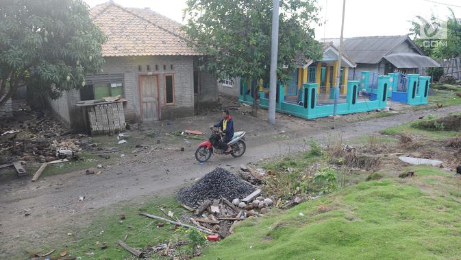 Pengendara motor melintas di dusun Regahan Lada, Pulau Sebesi, Lampung, Senin (31/12). Banyak warga dusun ini yang bertahan dan enggan meninggalkan rumahnya pascatsunami Selat Sunda pada 22 Desember lalu. (Liputan6.com/Herman Zakharia)