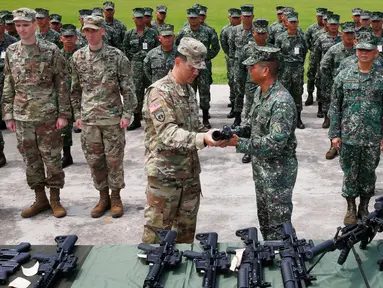 Komandan Korps Marinir Filipina, Mayjen Emmanuel Salamat menerima senapan M4 dengan peluncur granat dari Kolonel AS, Kolonel Ernest Lee di kota Taguig, sebelah timur Manila, Filipina (5/6). (AP Photo / Bullit Marquez)