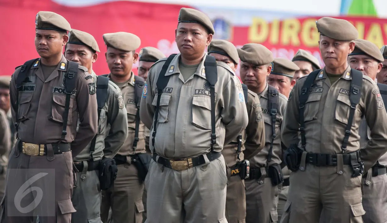Personel Satuan Polisi Pamong Praja (Satpol PP) berbaris saat mengikuti upacara hari ulang tahun Satpol PP dan Satuan Perlindungan Masyarakat (Satlinmas) di Jakarta, Kamis (27/4). (Liputan6.com/Gempur M. Surya)