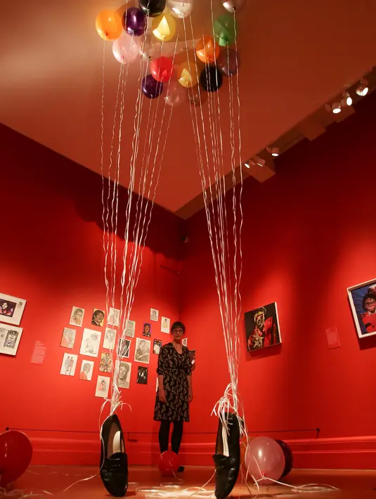 Petugas berpose dekat karya seni seniman Inggris Appau Jnr Boakye-Yiadom pada pameran 'Michael Jackson: On The Wall' di National Potrait Gallery, London, Rabu (27/6). Pameran ini berlangsung dari 28 Juni hingga 21 Oktober 2018. (Daniel LEAL-OLIVAS/AFP)