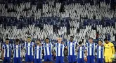 Sejumlah pemain FC Porto mengheningkan cipta dengan latar belakang para penonton yang sedang memegang plakat bergambar nomor punggung dua untuk mengenang kepergian Diogo Costa sebelum laga Liga Portugal 2025/2026 melawan Vitoria Guimaraes SC di Estadio Do Dragao, Porto, Portugal, Senin (11/08/2025) waktu setempat. (AFP/Miguel Riopa)