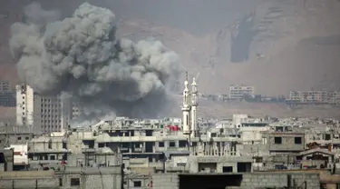 Kepulan asap membubung tinggi usai terjadi serangan udara dari pasukan Assad di wilayah Ghouta Timur, Suriah (7/2). Akibat serangan ini dilaporkan sedikitnya, 47 warga sipil tewas. (AFP Photo/Amer Almohibany)