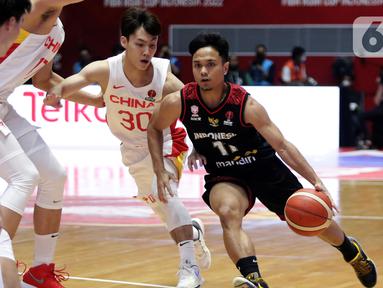 Pebasket Timnas Indonesia, Yudha Saputera (kanan) mencoba melewati adangan pemain China pada laga playoff perempat final FIBA Asia Cup 2022 di Istora Senayan, Jakarta, Senin (18/7/2022). Langkah timnas basket Indonesia di ajang FIBA Asia Cup 2022 terhenti usai menelan kekalahan telak 58-108 dari China. (Liputan6.com/Helmi Fithriansyah)