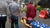 Polisi menggotong salah satu dari empat tahanan kabur dari penjara Polres Malang Kota yang ditembak saat ditangkap di tempat persembunyiannya (Liputan6.com/Zainul Arifin)
