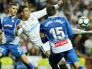 Bintang Real Madrid, Cristiano Ronaldo (tengah) melepaskan tembakan melewati adangan pemain Espanyol pada laga La Liga Santander di Santiago Bernabeu stadium, Madrid, (01/10/2017). Real Madrid menang 2-0. (AP/Paul White)