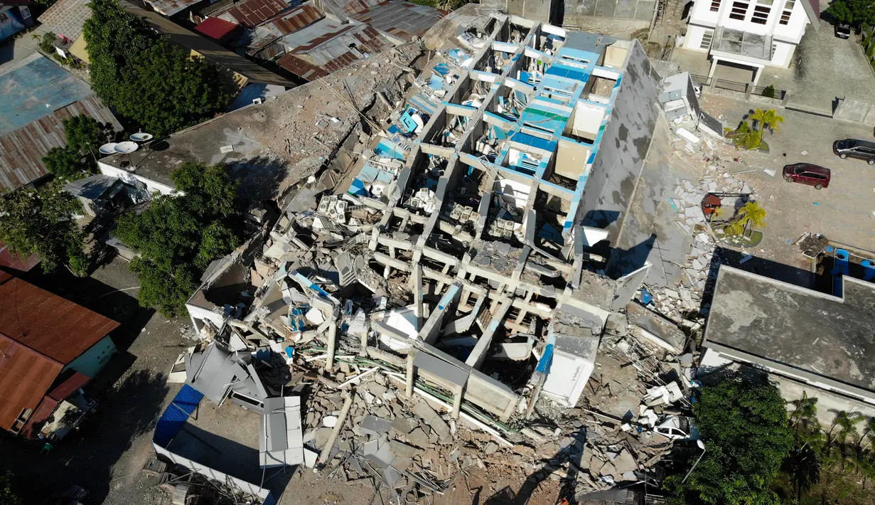 Petugas membersihkan puing-puing dari hotel Roa Roa yang runtuh di Palu, Sulawesi Tengah, Senin (1/10). Jumlah korban tewas akibat gempa dan tsunami yang melanda Palu dan Donggala diperkirakan akan meningkat. (JEWEL SAMAD/AFP)