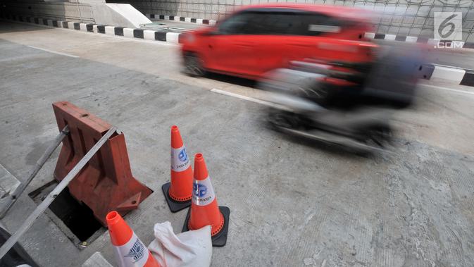 Pembatas jalan berwarna oranye diletakkan dekat penutup lubang saluran air yang hilang di Underpass Mampang-Kuningan, Jakarta, Kamis (23/8). Besi-besi penutup saluran air itu menyisakan lubang yang membahayakan pengendara. (Merdeka.com/Iqbal S. Nugroho)