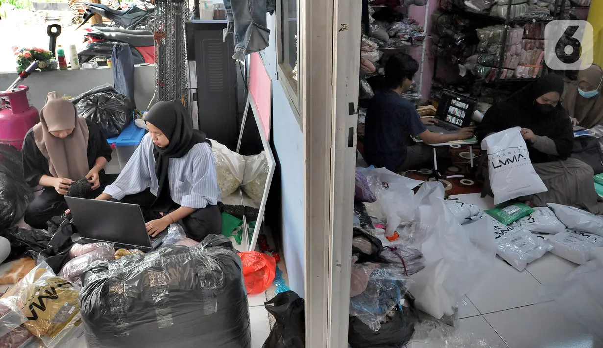 Pekerja membungkus baju muslim pesanan secara online di home industri busana muslim Albarizk UMMA di kawasan Beji, Depok, Selasa (12/4/2022). Mendekati lebaran, penjualan jilbab dan busana musim secara online meningkat 100 persen dibandingkan tahun lalu saat masa pandemi. (merdeka.com/Arie Basuki)