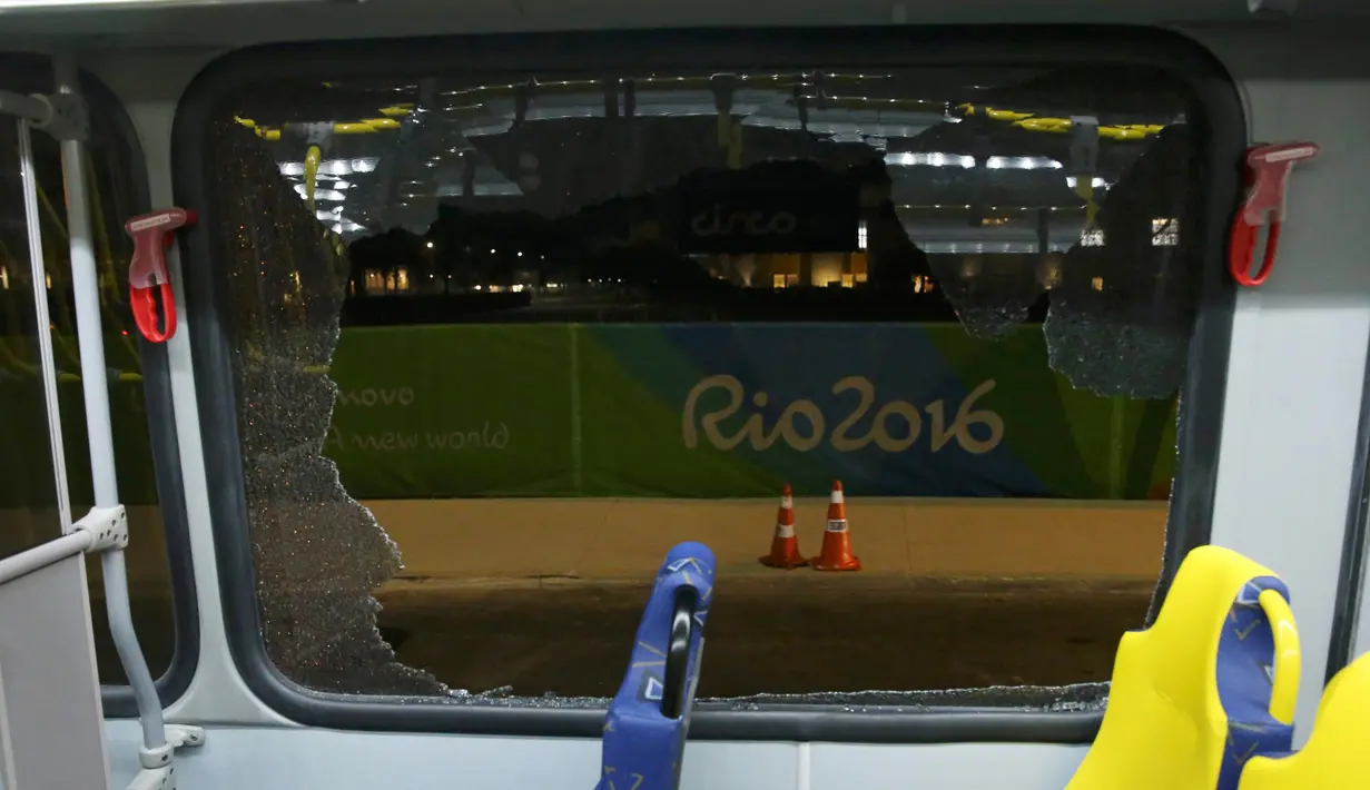 Kaca jendela dari bus yang mengangkut para jurnalis di Olimpiade Rio 2016 pecah ketika dalam perjalanan menuju pusat media centre di Barra da Tijuca, Selasa (9/8). Bus tersebut ditembak senjata api oleh orang tak dikenal. (REUTERS/Shannon Stapleton)