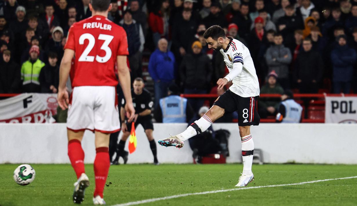Pemain Manchester United, Bruno Fernandes (kanan) menendang bola ke gawang Nottingham Forrest dan mengonversi menjadi gol di menit ke-89 dalam semi final leg pertama Carabao Cup 2022/2023 di The City Ground, Kamis (26/1/2023). (AFP/Darren Staples)