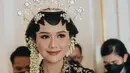 Saat menikah, Erina Gudono tampil dengan kebaya hitam velvet dihiasi bordiran emas. Dipadukan kalung dan bros keemasan pula. [@erinagudono]