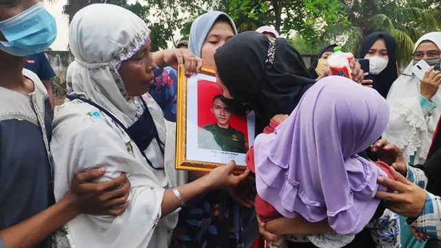 Istri prajurit TNI Gugur di Poso mencium foto suaminya itu saat pemakaman di Pekanbaru.