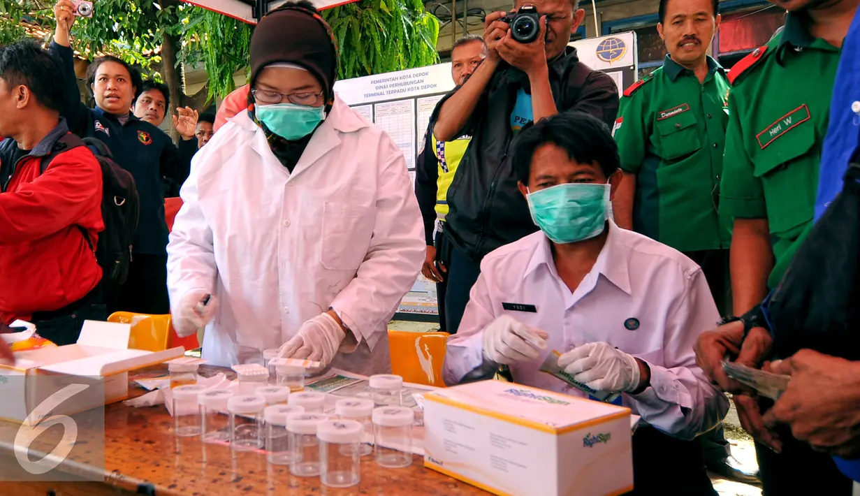 Tim medis melakukan pengecekan kesehatan tekanan darah dan tes urin  di terminal Depok, Senin (13/7/2015). Puluhan bus termasuk sopir yang berada di terminal Depok melakukan pengecekan tes kesehatan dan urine. (Liputan6.com/Yoppy Renato)