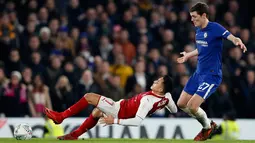 Pemain Arsenal Alexis Sanchez terjatuh di depan pemain Chelsea Andreas Christensen saat berebut bola pada laga semifinal pertama Piala Liga Inggris di Stadion Stamford Bridge, Rabu (10/1). Chelsea harus puas diimbangi Arsenal 0-0. (AP/Kirsty Wigglesworth)