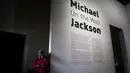 Seorang wanita bersandar di dinding pintu masuk pameran Michael Jackson: On The Wall di museum Grand Palais, Paris, Rabu (21/11). Pameran menampilkan karya seni yang terinspirasi oleh lagu, koreografi dan video klip Michael Jackson. (Philippe LOPEZ/AFP)