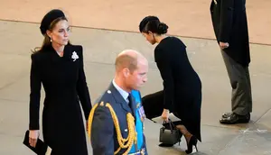 Kate Middleton (kiri), Pangeran William (ke-2 dari kiri), Meghan Markle (ke-2 dari kanan), dan Pangeran Harry (kanan) memberi penghormatan di dalam Westminster Hall di Istana Westminster, tempat peti mati Ratu Elizabeth II dibaringkan pada 14 September 2022. (Christopher Furlong/POOL/AFP)
