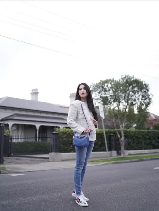Simple tapi chic, kali ini Sandra Dewi tampil menawan memadukan tweed blazer warna krem, skinny jeans, sneakers penuh warna, serta sling bag warna biru. (Instagram/sandradewi88).