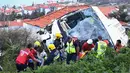 Petugas penyelamat mengevakuasi korban kecelakaan sebuah bus pariwisata di Kota Canico, Pulau Madeira, Portugal, Rabu (17/4). Sebanyak 28 orang yang sebagian besar turis dari Jerman, meninggal dunia, sementara 22 lainnya terluka dalam insiden tersebut. (Rui Silva/Aspress/Global Imagens via AP)
