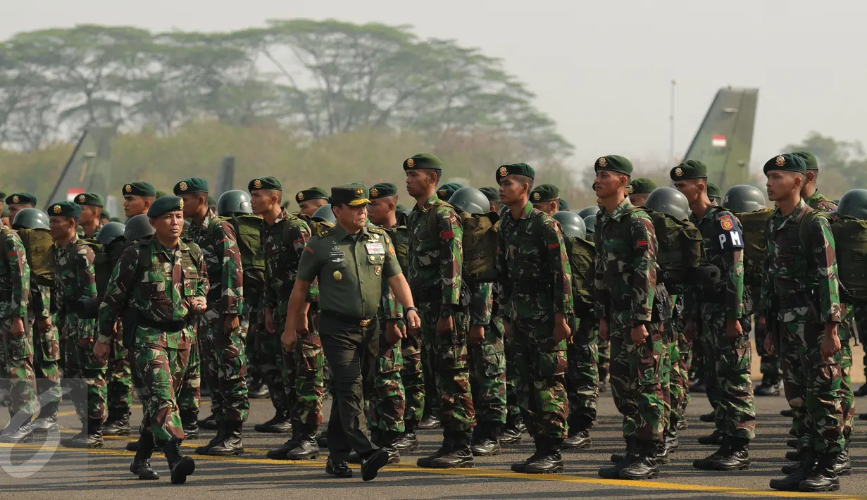 AsOps Panglima TNI, Mayjen TNI Fransen G Siahaan (kanan depan) memeriksa pasukan yang akan menuju Sumatera Selatan di Lanud Halim Perdanakusuma Jakarta, Kamis (22/10/2015). Satgas ini akan bertugas selama dua bulan. (Liputan6.com/Helmi Fithriansyah)