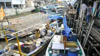 Warga penghuni pasar ikan Penjaringan menyelamatkan barang-barang miliknya ke perahu nelayan untuk sementara, Jakarta (11/4). Pemprov DKI membongkar ratusan rumah di Pasar ikan, Aquarium dan Luar Batang, Penjaringan, Jakarta. (Liputan6.com/Yoppy Renato)