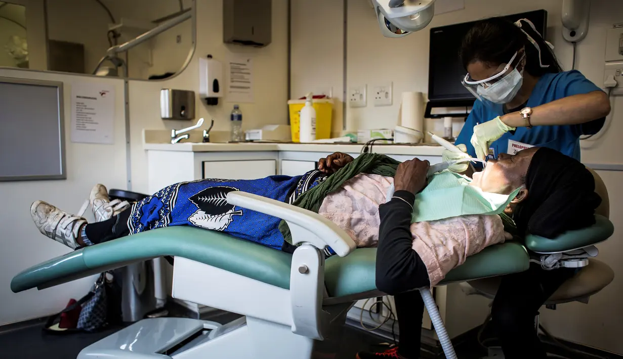 Dokter saat memeriksa gigi pasien di kereta kesehatan Phelophepha, Afrika Selatan, Senin (6/3). Kereta medis ini melayani pemeriksaan gigi, mata, optometri, hingga psikologi. (AFP Photo/ JOHN WESSELS)