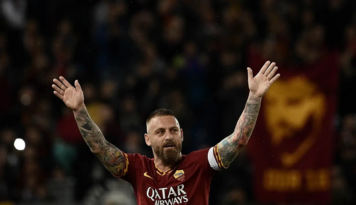 Gelandang AS Roma, Daniele De Rossi, menyapa suporter usai melawan Parma pada laga Serie A di Stadion Olympic, Roma, Minggu (26/5). Laga ini perpisahan bagi De Rossi dan AS Roma setelah 18 tahun. (AFP/Filippo Monteforte)