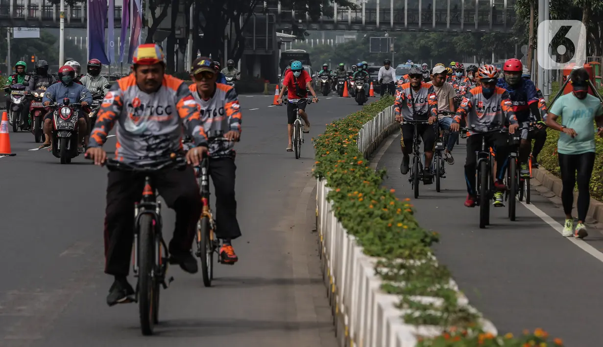 Warga bersepeda melintasi kawasan Sudirman - Thamrin saat akhir pekan, Jakarta, Minggu (20/2/2022). Aktivitas warga di kawasan tersebut relatif ramai saat Pemberlakuan Pembatasan Kegiatan Masyarakat (PPKM) level tiga di ibu kota. (Liputan6.com/Johan Tallo)