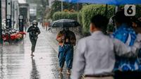 Pejalan kaki menggunakan payung saat hujan deras mengguyur kawasan Jalan Thamrin, Jakarta, Selasa (31/5/2022). Kecepatan angin maksimum mencapai 20 kt dan tekanan udara minimum 1005,8 mb.  (Liputan6.com/Faizal Fanani)