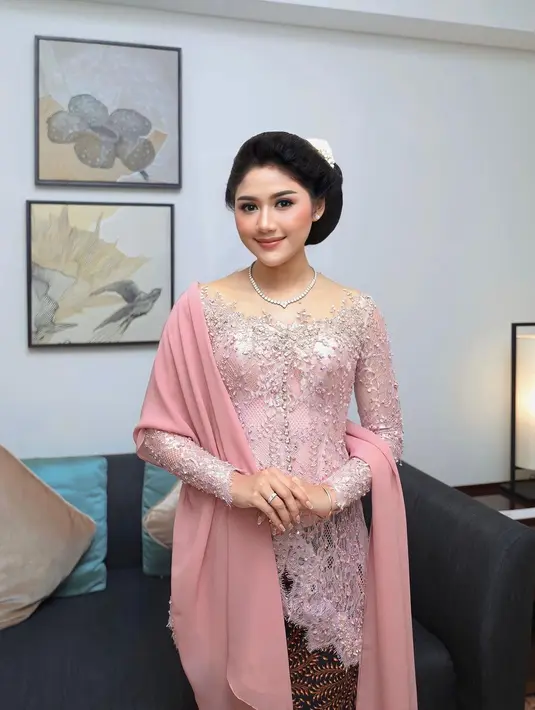 Erina Gudono memilih kebaya boatneck pink untuk kesan feminin yang elegan. Kebaya full payet silver itu dipadukan dengan kain batik dan selendang polos [@erinagudono]