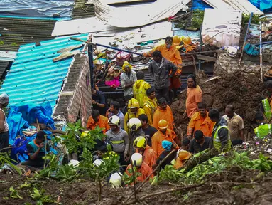 Pasukan Tanggap Bencana Nasional dan tim penyelamat lainnya memeriksa lokasi tanah longsor di daerah kumuh di Mumbai, India, Minggu (18/7/2021). Sebanyak 18 orang tewas setelah beberapa rumah hancur oleh dinding yang runtuh dan akibat tanah longsor yang dipicu oleh hujan lebat. (Sujit Jaiswal/AFP)
