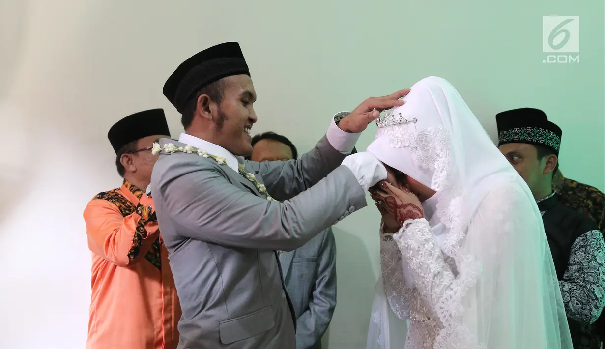 Komedian Caisar Aditya Putra mendapat ciuman di tangan oleh Intan Sri Mardiani usai melangsungkan ijab kabul pernikahan di kawasan Cimahpar, Bogor, Jawa Barat, Sabtu (30/6). (Liputan6.com/Herman Zakharia)
