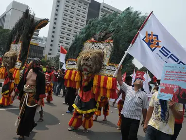 Massa aksi Hari Buruh Internasional membawa reog saat long march dari Tugu Tani ke depan Istana Merdeka hingga ke Monas, Jakarta, Senin (1/5) Dalam aksinya para buruh meminta sistem kerja kontrak dan upah rendah dihapus. (Liputan6.com/Helmi Afandi)