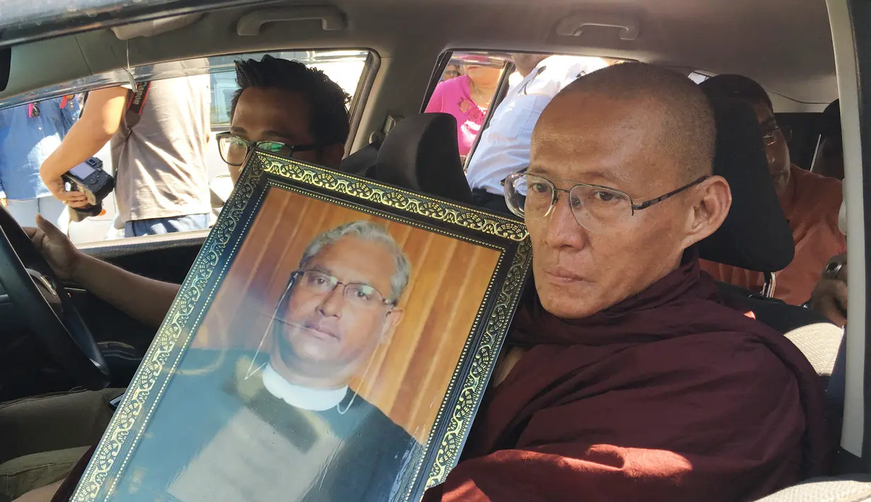 Seorang biksu Buddha memegang potret Ko Ni saat pemakaman Ko Ni di Yangon, Myanmar (30/1). Ko Ni adalah salah seorang figur Muslim ternama di negara yang mayoritasnya beragama Buddha itu. (AP Photo/Esther Htusan)