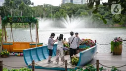 Wisatawan berfoto saat mengunjungi Senayan Park, Jakarta, Rabu (9/12/2020). Libur Nasional Pilkada Serentak 2020 dimanfaatkan sebagian warga Jakarta dan sekitarnya untuk mengunjungi tempat rekreasi bersama keluarga. (Liputan6.com/Faizal Fanani)