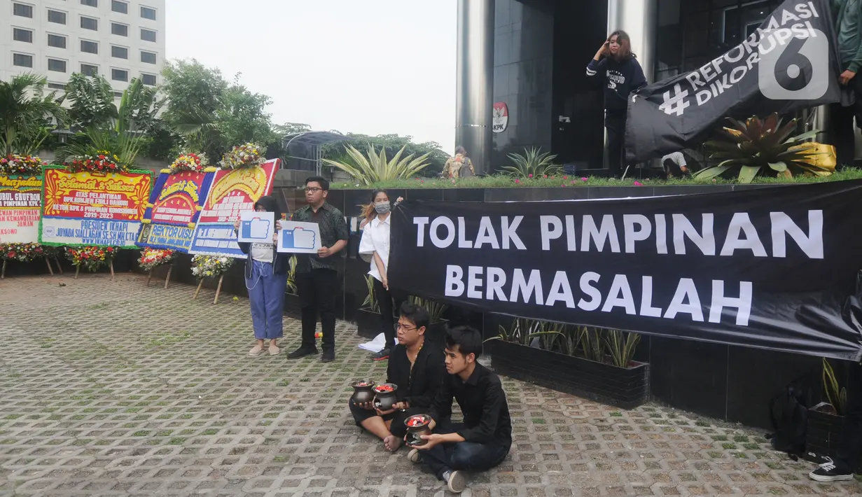 Aktivis dari Indonesia Corruption Watch (ICW) melakukan aksi teatrikal menolak kehadiran pimpinan KPK bermasalah di depan Gedung Merah Putih KPK, Jakarta, Jumat (20/12/2019). Aksi penolakan digambarkan dengan keberadaan dua dukun yang tengah mengusir roh jahat. (merdeka.com/Dwi Narwoko)