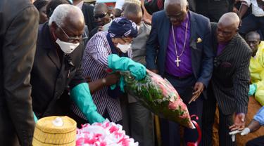 Presiden Sierra Leone Ernest Bai Koroma (kedua kiri) dan Presiden Liberia Ellen Johnson Sirleaf (tengah) meletakan bunga saat menghadiri pemakaman korban longsor di pemakaman Paloko, Waterloo, Sierra Leone,(17/8). (AFP Photo/Seyllou)