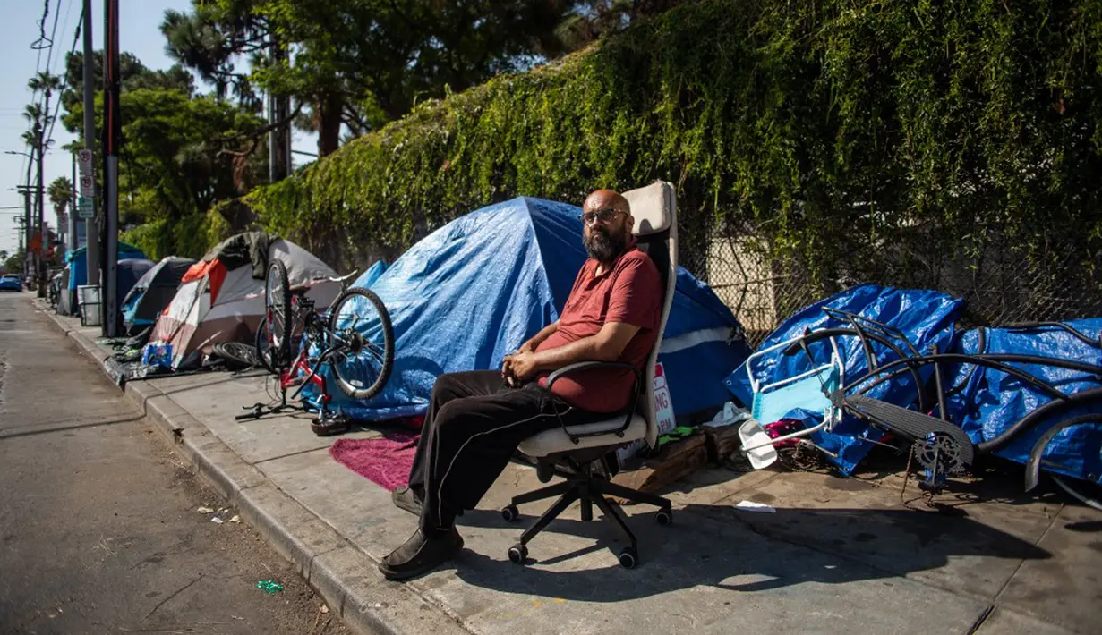Albert Martinez, yang telah hidup selama 20 tahun di jalanan Los Angeles, duduk di luar tendanya di trotoar di Venice Beach, California, Amerika Serikat, 12 Agustus 2021. (Apu GOMES/AFP)