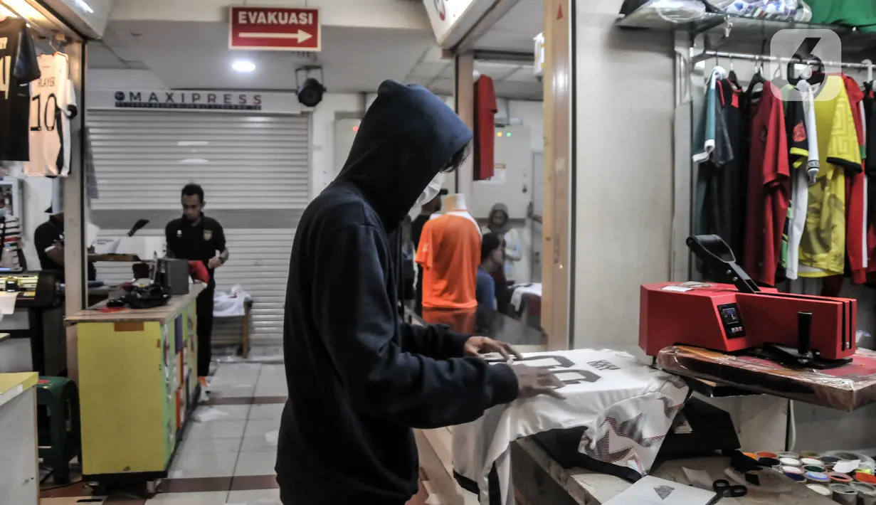 Pekerja menyelesaikan sablon jersey sepak bola di salah satu kios Blok B Pasar Tanah Abang, Jakarta Pusat, Kamis (8/12/2022). Perhelatan Piala Dunia 2022 membawa berkah tersendiri bagi jasa sablon jersey sepak bola di Pasar Tanah Abang yang diakui mengalami peningkatan pesanan hingga 80 persen dibandingkan bulan sebelumnya. (merdeka.com/Iqbal S. Nugroho)