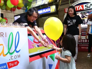 CEO MatahariMall.com Hadi Wenas membagikan balon dan hadiah, kepada seorang anak pada Hari Pelanggan Nasional di Gajah Mada Plaza, Jakarta, Minggu (04/9). Kegiatan ini juga menyambut ulang tahun pertama MatahariMall.com. (Liputan6.com/Fery Pradolo)