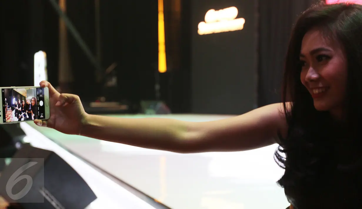 Model memperagakan Oppo F3 saat peluncuran di Jakarta, Kamis (04/05). Oppo F3 dibekali kamera utama beresolusi 13MP dengan Optical Image Stabilization (OIS), LED flash, dengan sensor 1/2.8 inci. (Liputan6.com/Herman Zakharia)
