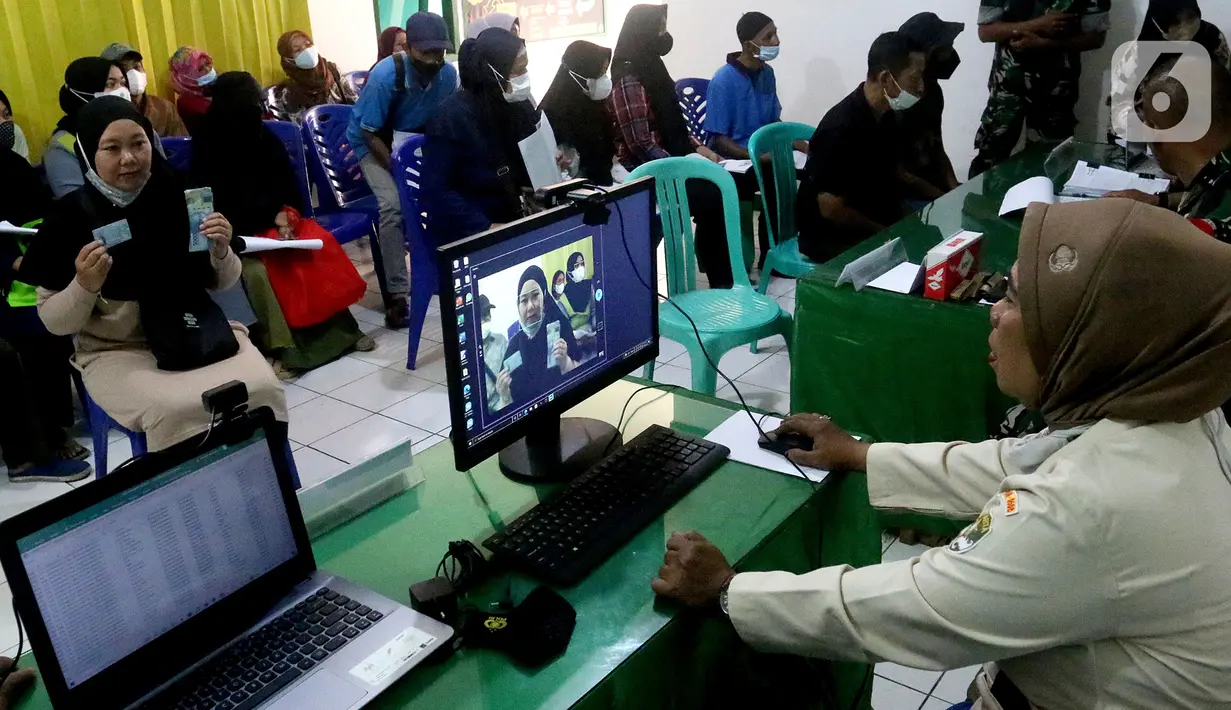 Petugas mengambil foto warga penerima Bantuan Langsung Tunai (BLT) minyak goreng di Koramil 02 Beji, Kota Depok, Jawa Barat, Kamis (19/5/2022). Pemerintah melalui TNI mendistribusikan BLT minyak goreng sebesar Rp300 ribu per orang untuk masyarakat penerima manfaat. (merdeka.com/Arie Basuki)