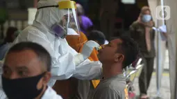 Petugas medis mengambil sampel lendir saat tes usap (swab test) pegawai kecamatan Sawah Besar, Jakarta, Selasa (18/8/2020). Tes swab yang dilakukan terhadap seluruh pegawai kecamatan Sawah Besar itu sebagai upaya memutus mata rantai penyebaran Virus Corona Covid-19. (merdeka.com/Imam Buhori)