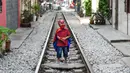 Seorang anak mengenakan kostum Spiderman berdiri di rel kereta yang populer sebagai lokasi selfie di Hanoi, Vietnam, Kamis (10/10/2019). Rel kereta tersebut dibangun pada tahun 1902 di bawah penguasa kolonial Prancis. (Nhac NGUYEN/AFP)