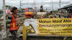 Seorang pekerja melintas di depan proyek penambahan panjang peron 6 dan 7 Stasiun Bogor, Jawa Barat, Rabu (16/12/2015). Penambahan panjang peron dilakukan untuk lebih memberikan kenyamanan bagi pengguna KRL. (Liputan6.com/Helmi Fithriansyah)