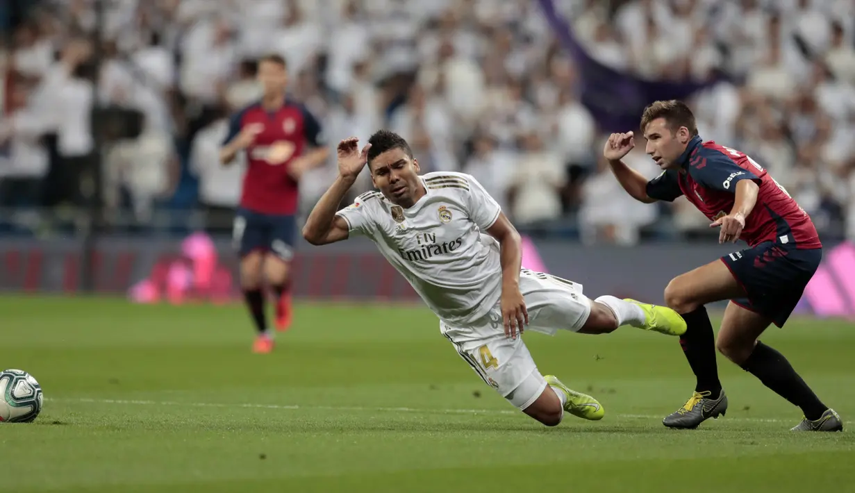 Gelandang Real Madrid, Casemiro saat dilanggar pemain Osasuna, Jon Moncayola pada lanjutan pertandingan La Liga di stadion Santiago Bernabeu, Spanyol (25/9/2019). Real Madrid menang 2-0 atas Osasuna. (AP Photo/Bernat Armangue)