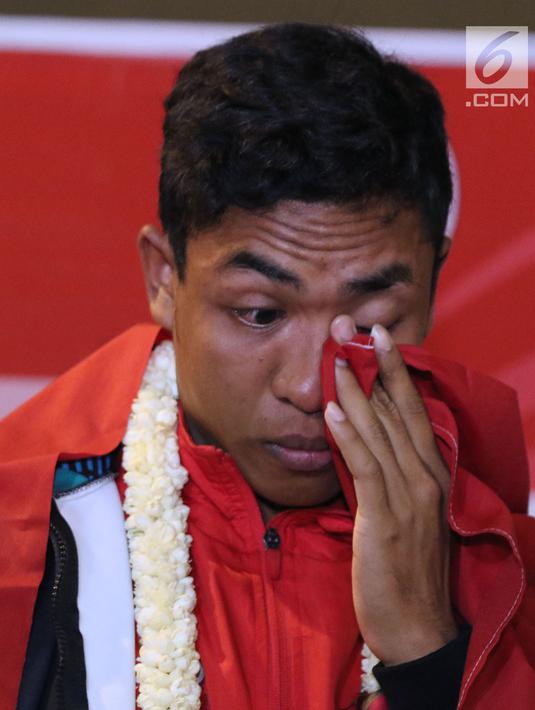 Pelari muda Indonesia, Lalu Muhammad Zohri mengusap mata saat upacara penyambutan di Terminal 3 Bandara Soetta, Tangerang, Selasa (17/7). Lalu M Zohri meraih emas lari 100m putra di Kejuaraan Dunia Atletik U-20. (Liputan6.com/Helmi Fithriansyah)