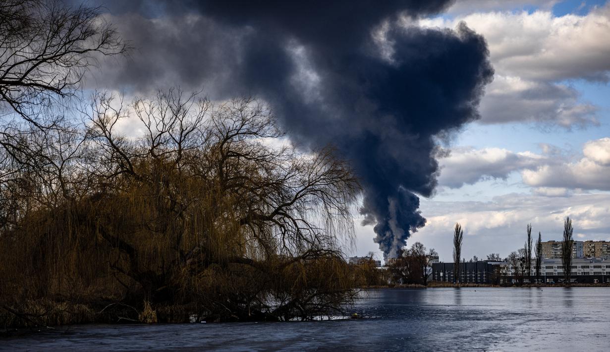 Asap mengepul setelah serangan rudal Rusia menghantam depot minyak di kota Vasylkiv di luar Kiev, Ukraina (27/2/2022). Menteri luar negeri Ukraina mengatakan pada 27 Februari, bahwa Kyiv tidak akan menyerah pada pembicaraan dengan Rusia mengenai invasinya. (AFP/Dimitar Dilkof)