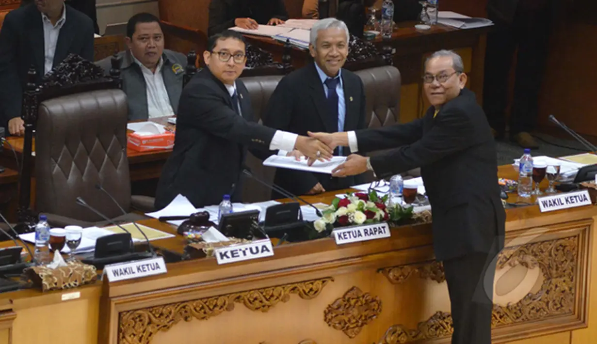 Fadli Zon (kiri) menerima hasil pembahasan tingkat 1 dari Ketua Komisi II Rambe Kamarulzaman (kanan) saat rapat paripurna DPR, Jakarta, Selasa (17/2/2015). Dalam rapat tersebut DPR mengesahkan revisi UU Pilkada dan UU Pemda. (Liputan6.com/Andrian M Tunay)
