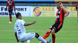 Pemain serbabisa Persipura Robertino Pugliara berduel dengan bek Bali United Wahyu Kristanto. (Liga Indonesia)